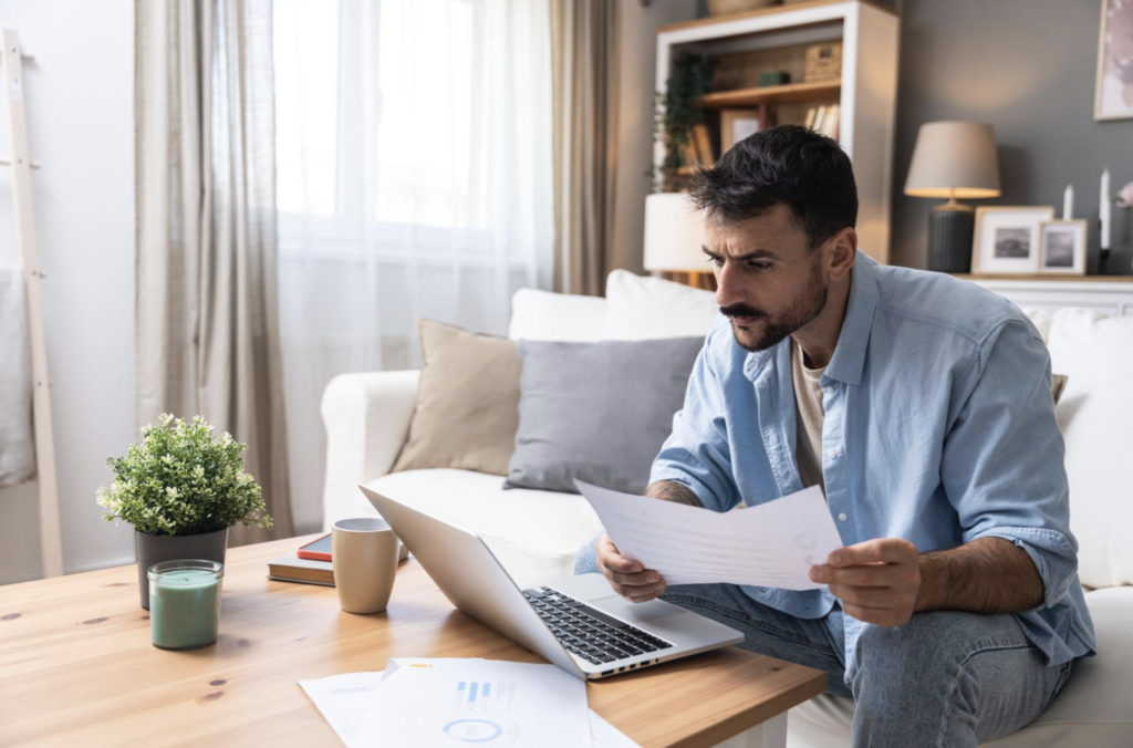 Self-employed renter organizing bank statements tax returns invoices and apartment application documents.