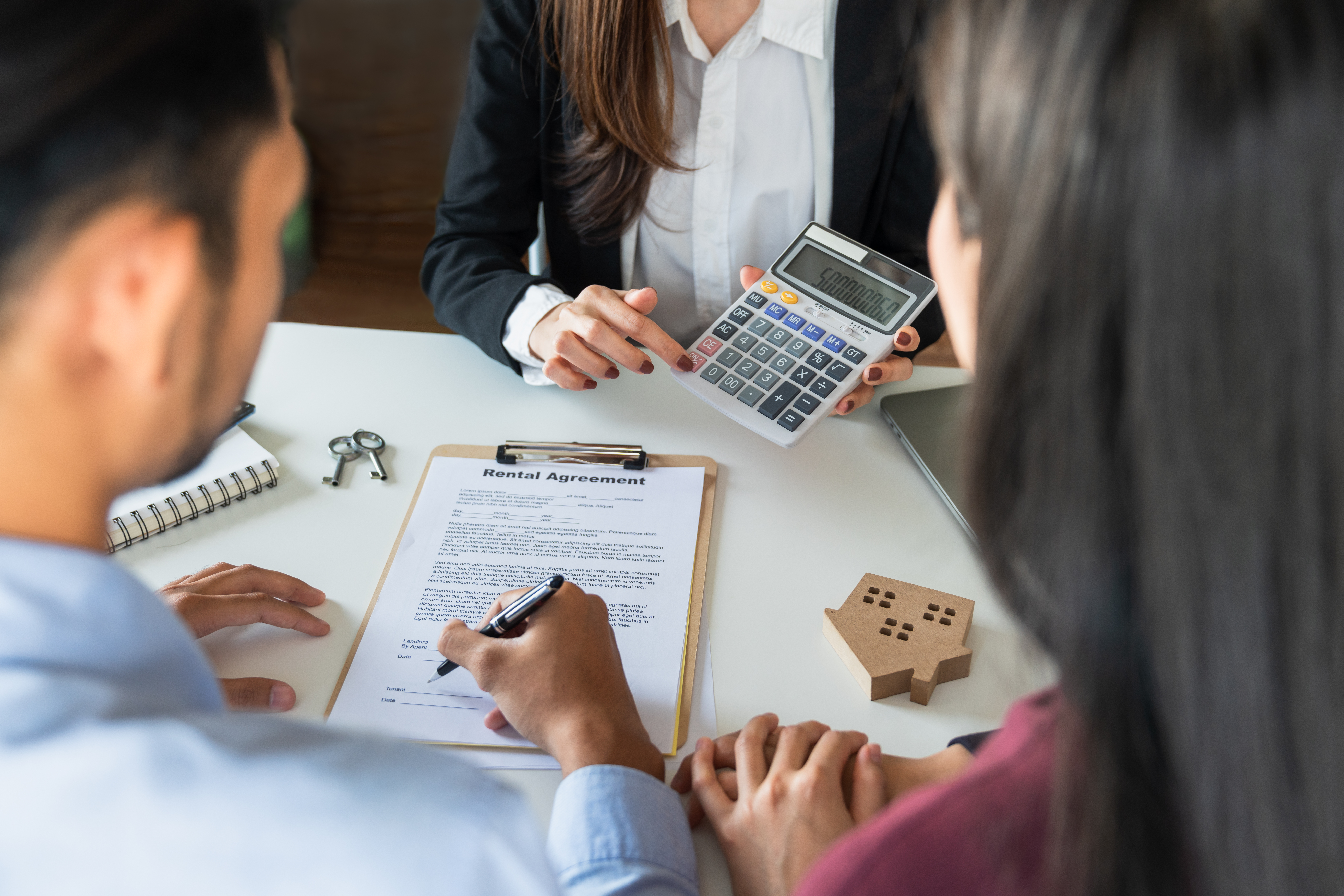 Renter and co-signer reviewing an apartment lease agreement together before applying.