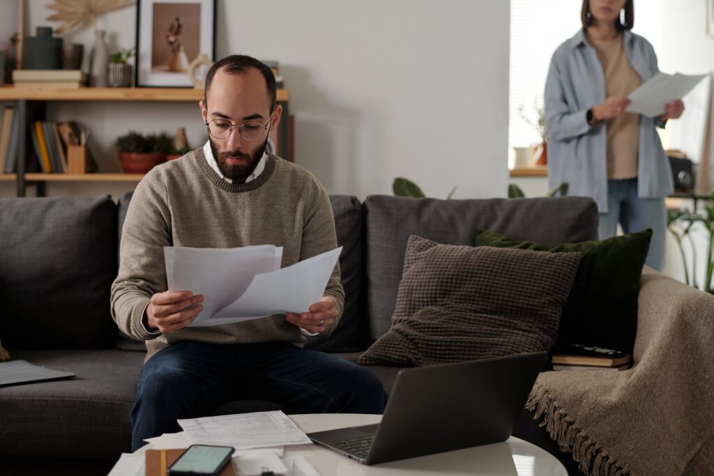 Renter reviewing collections on credit report while preparing apartment application documents.