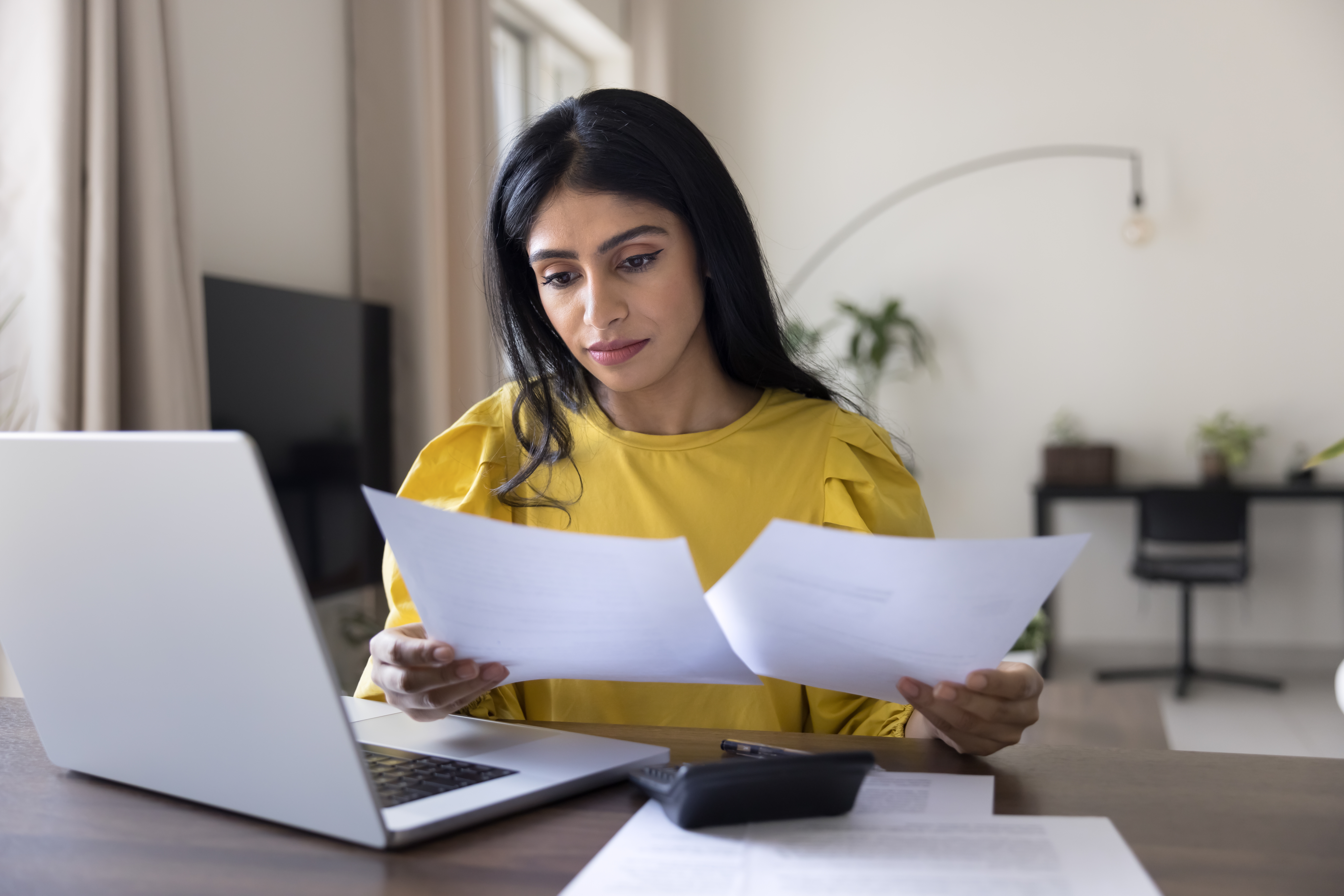 Renter organizing apartment application documents including ID pay stubs rental references and proof of income.
