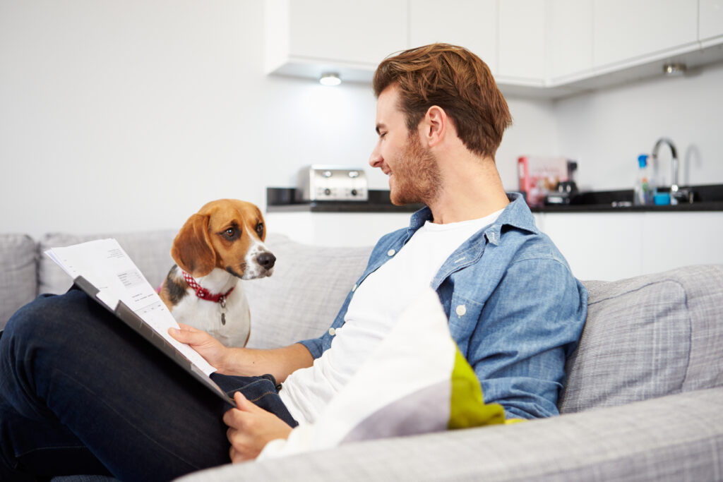 Renter with dog reviewing rent-to-own home agreement and pet policy before signing lease paperwork.