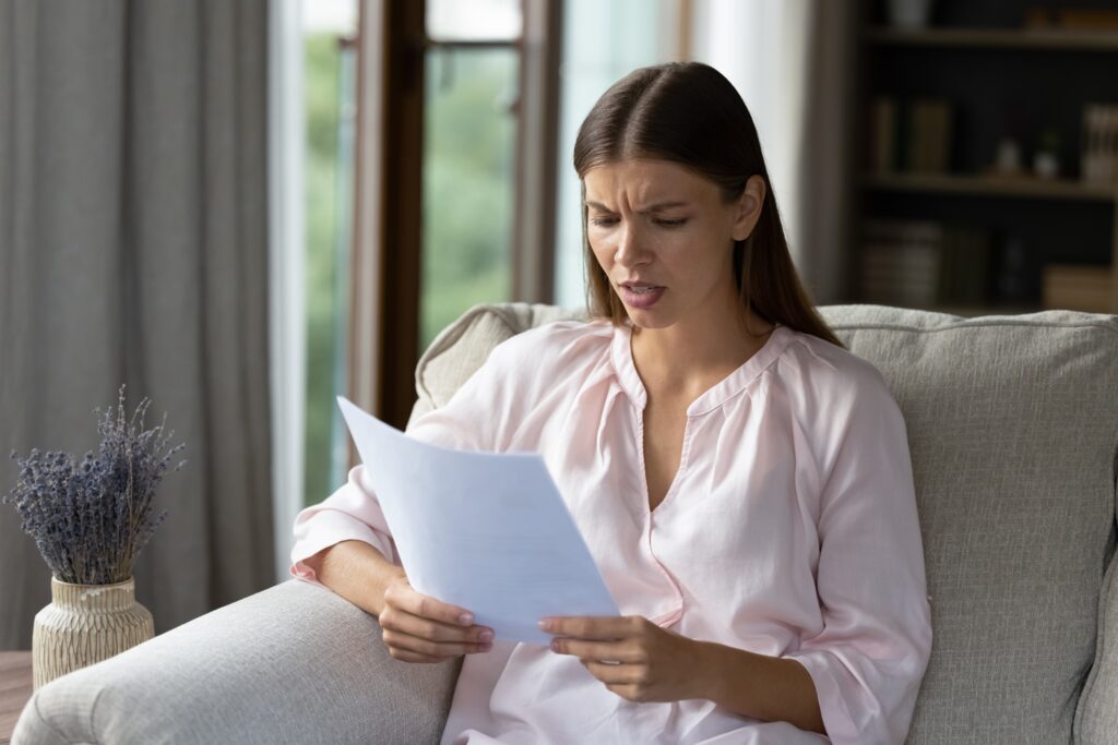 Renter reviewing apartment application denial notice tenant screening report and credit documents.