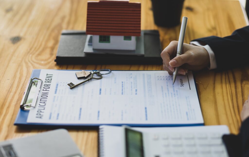 First-time landlord preparing rental property documents keys lease agreement and tenant application forms.