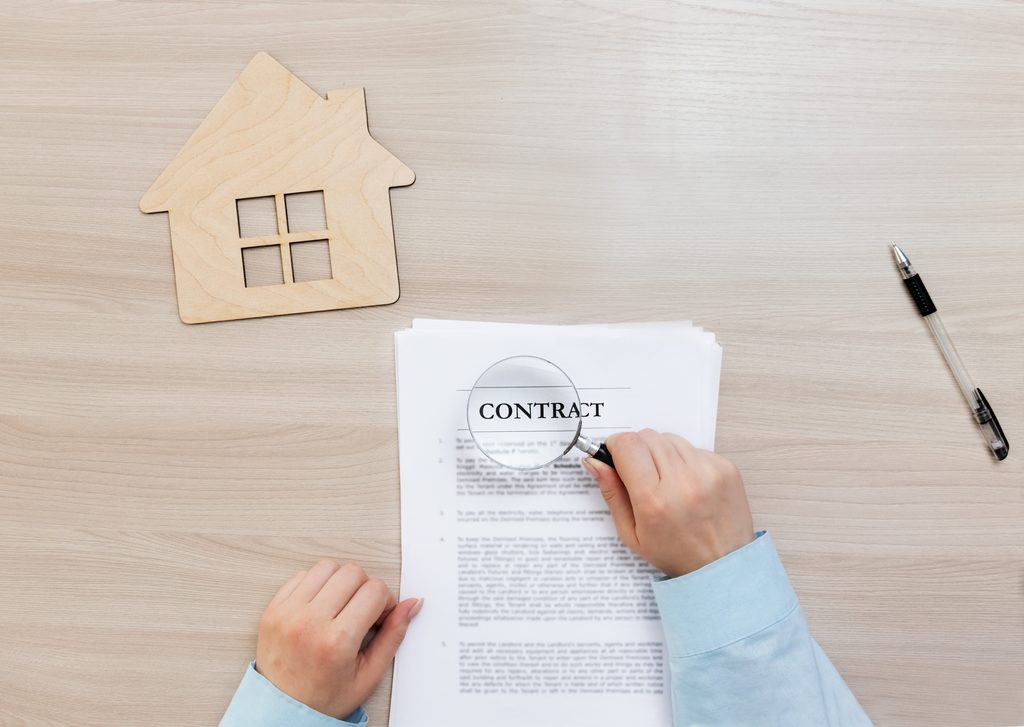 Renter reviewing a rent-to-own home agreement and checking costs risks and contract terms before signing.